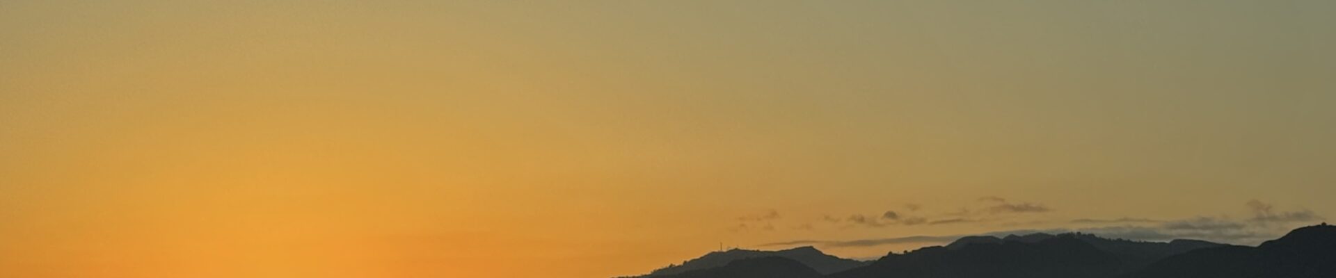 sunset over a beach with mountains